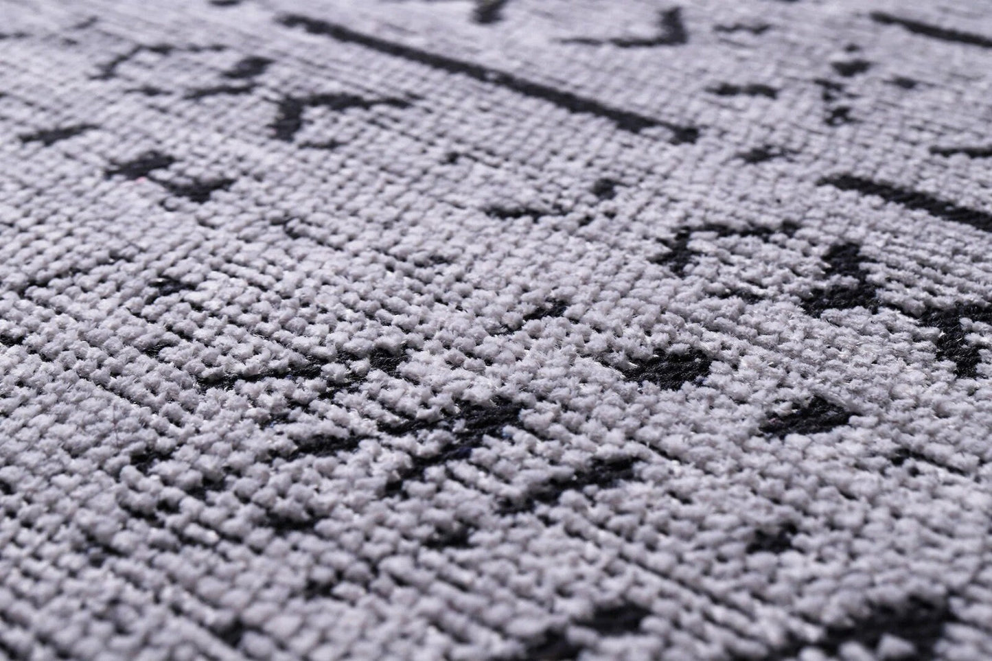 Close-up of gray textile with black geometric patterns and textured woven surface