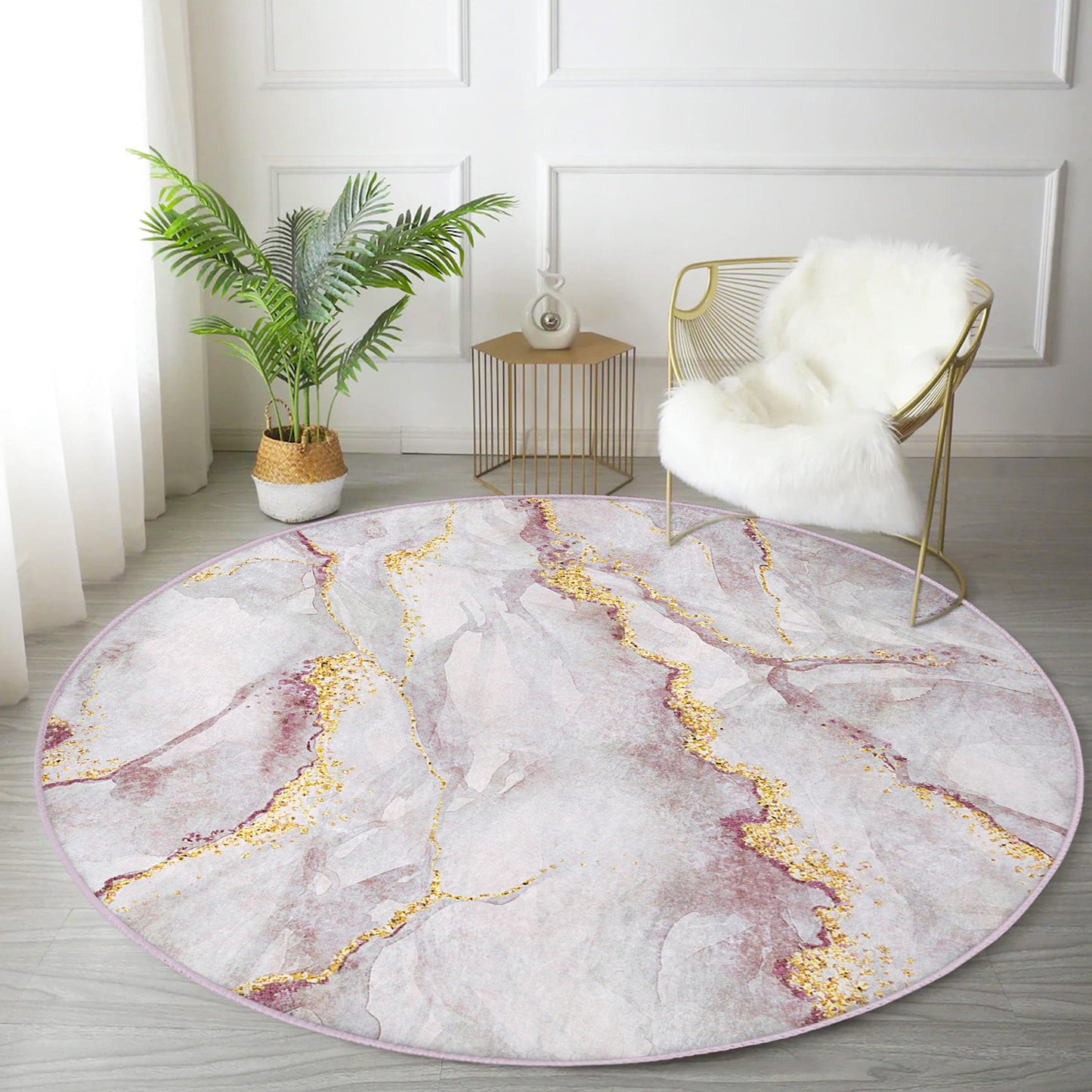 Round marble-patterned area rug with gold accents in modern living room featuring gold wire chair with white fur throw and potted plant