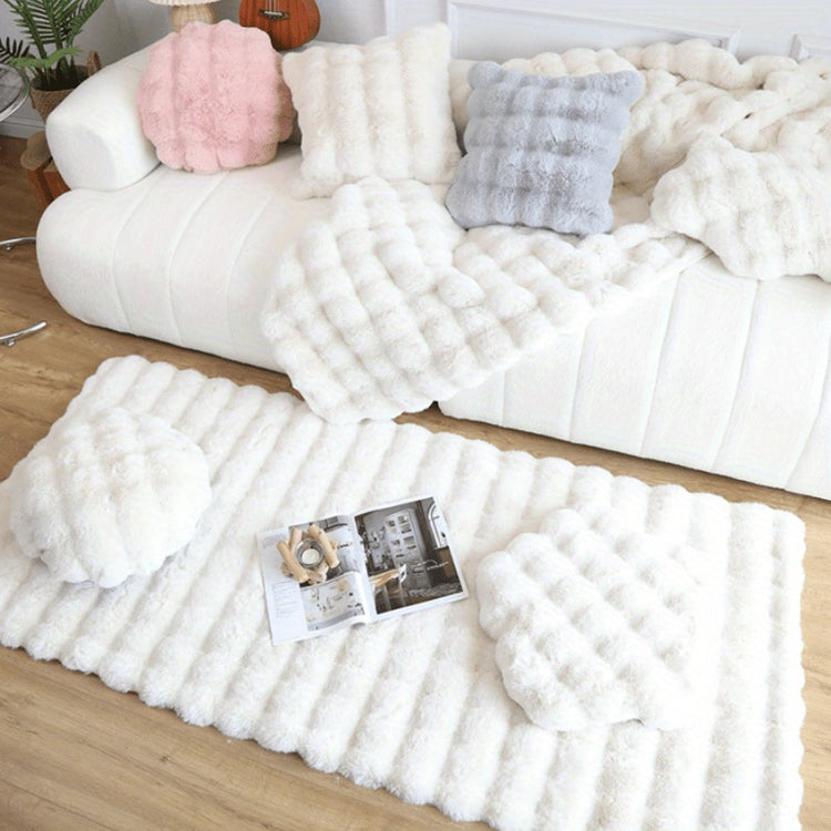 White plush bubble texture pillows and throw blanket on white sofa with matching fluffy rug on wooden floor