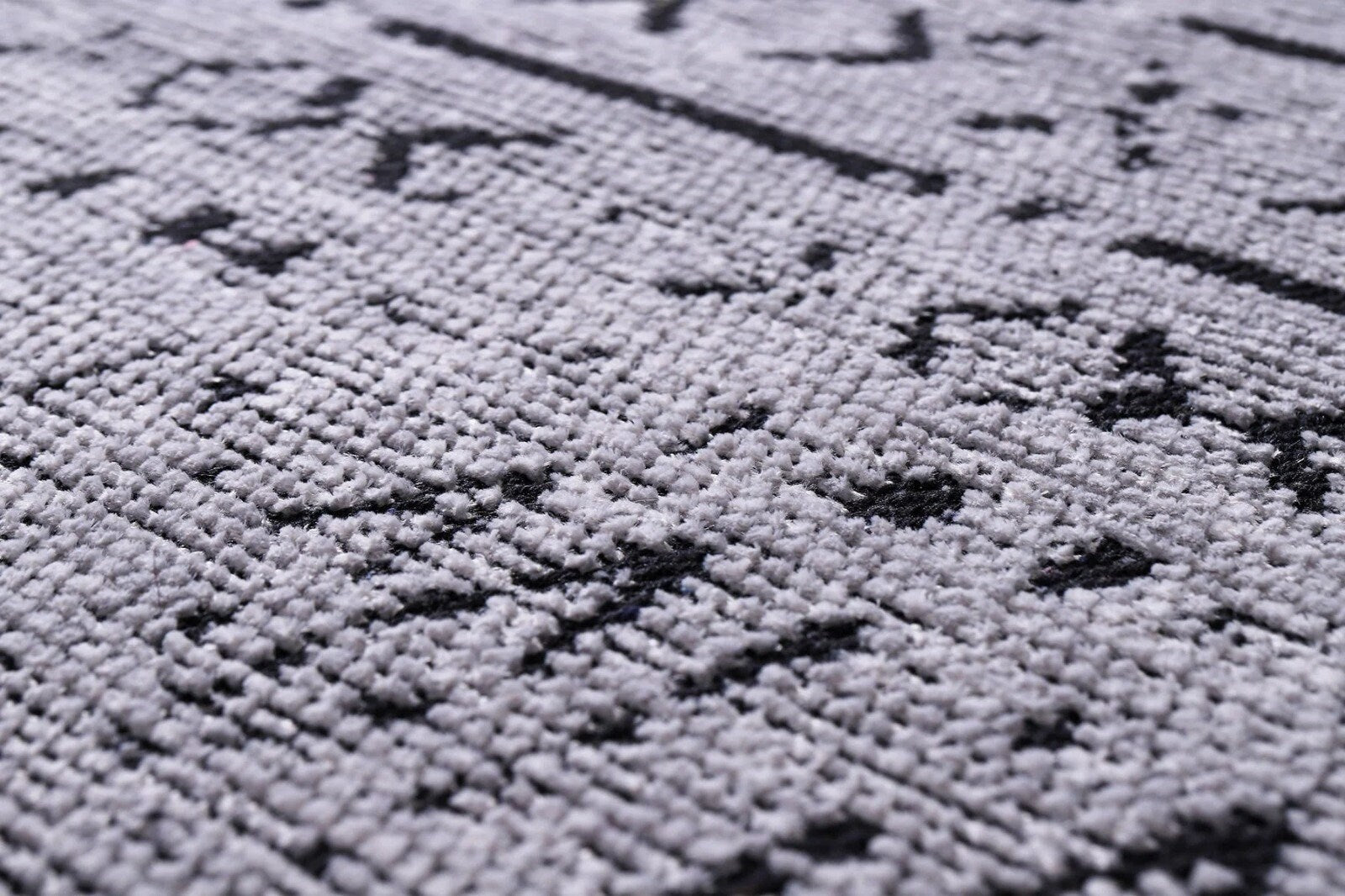 Close-up of gray textile with black geometric patterns and textured woven surface