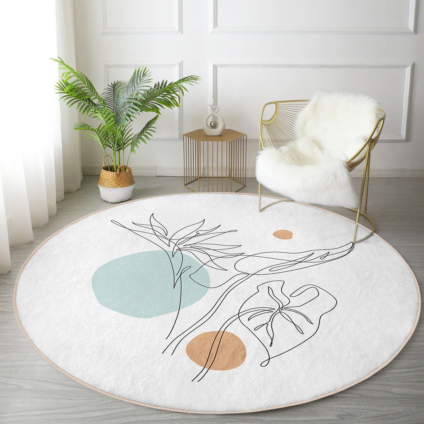 Modern living room with round white rug featuring abstract botanical design, gold wire chair with white fur throw, and potted plant