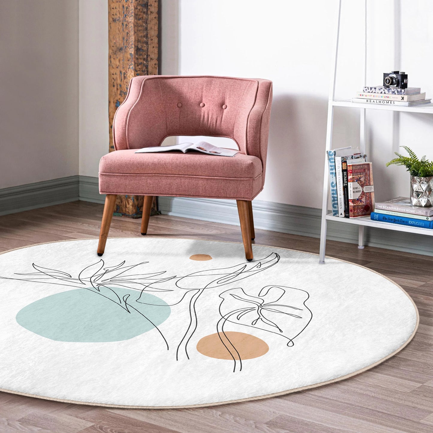 Pink upholstered accent chair on round white rug with abstract leaf design in modern living room