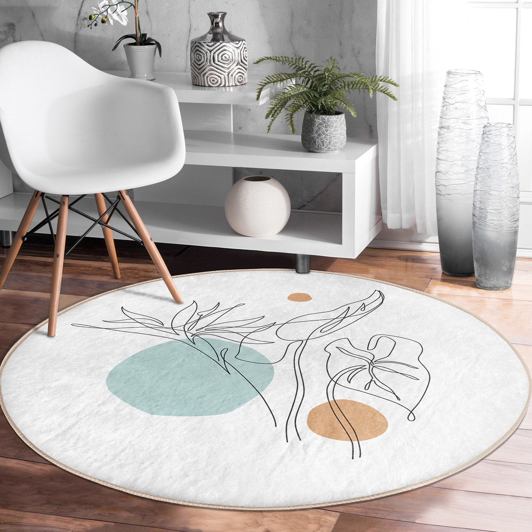 Modern living room with white chair, geometric vases, potted plants, and round abstract rug on wooden floor