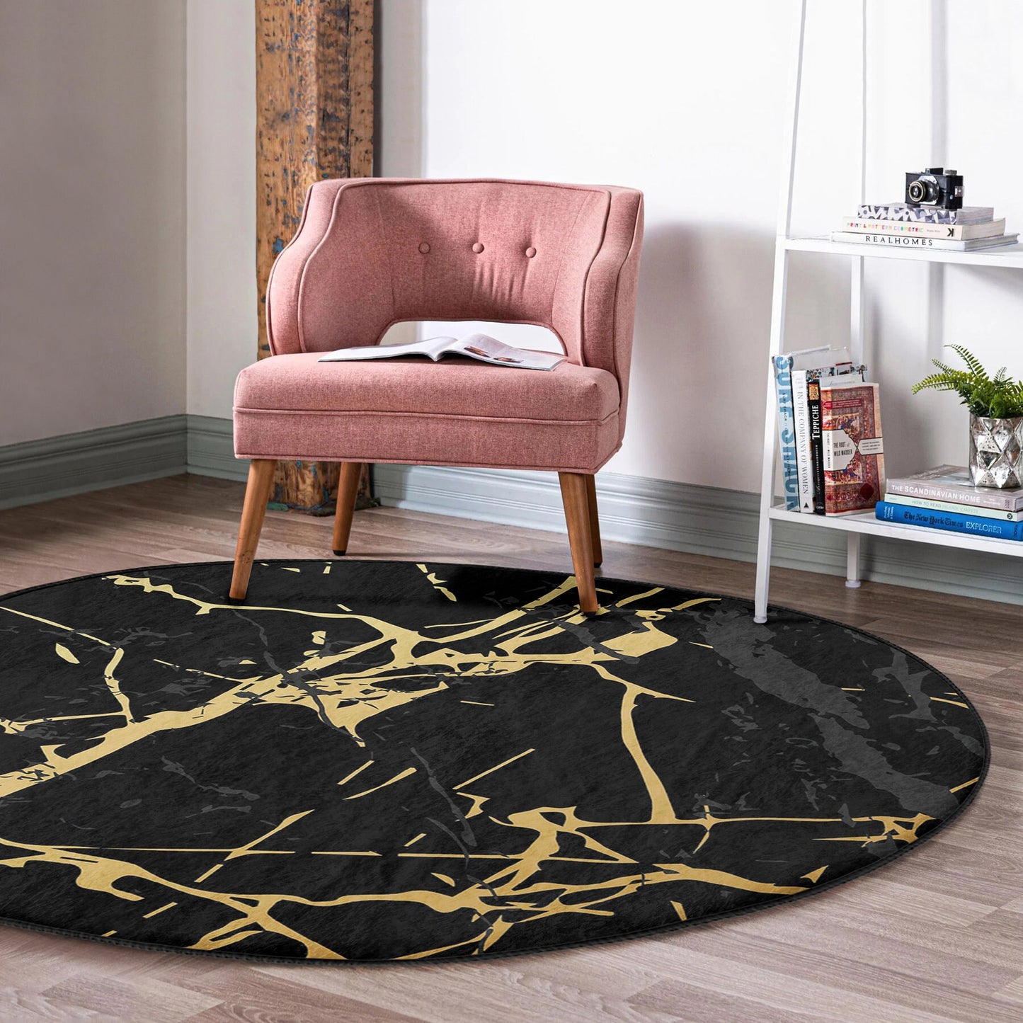 Pink tufted armchair on a black and gold abstract round rug in a modern living room setting