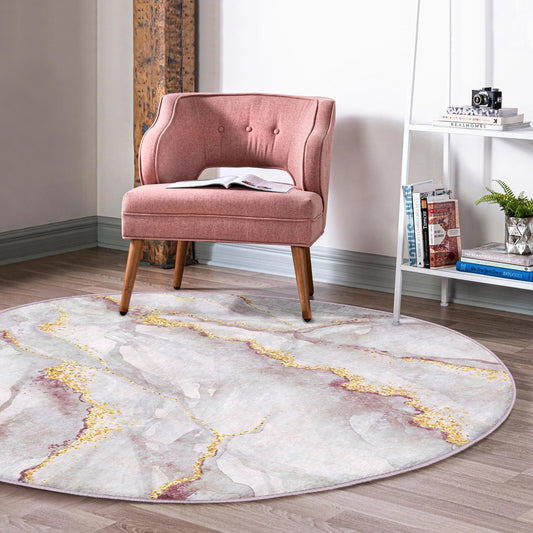 Pink upholstered accent chair on a round marble-patterned rug in a bright modern room with bookshelf