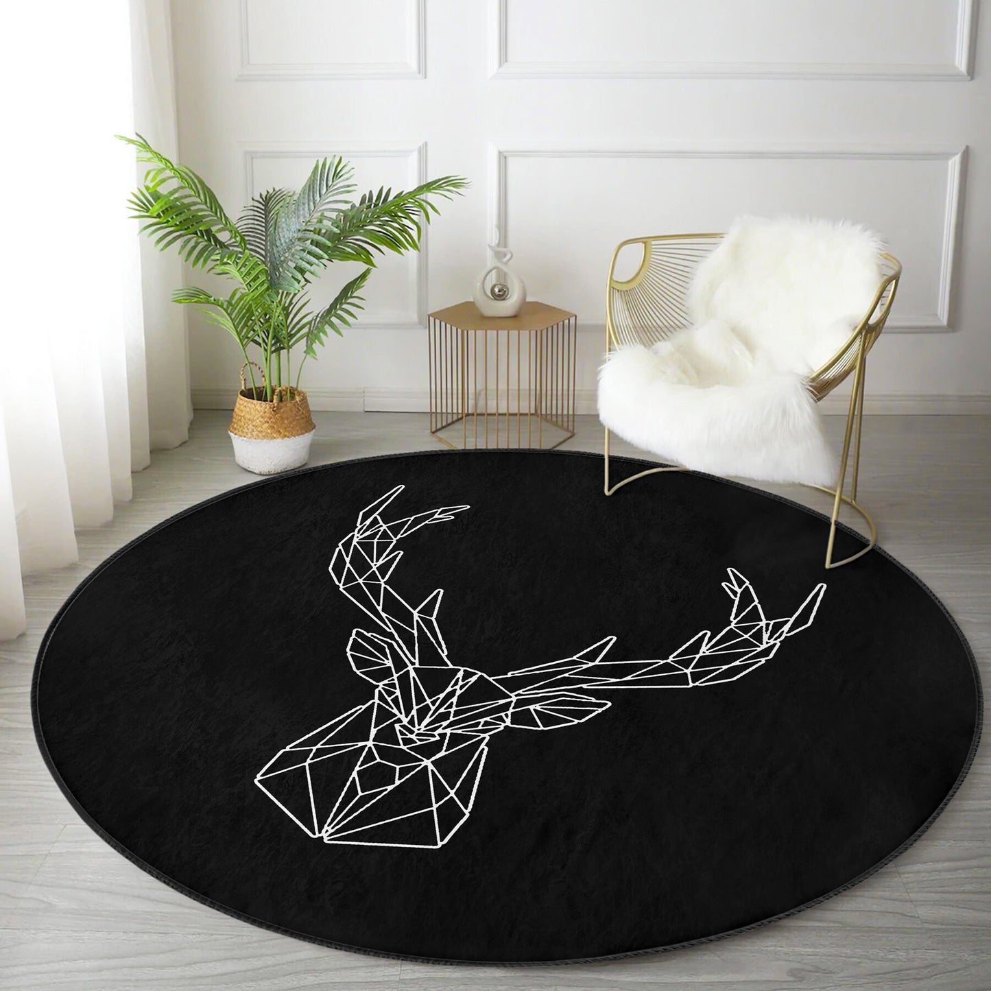 Modern living room with black round rug featuring white geometric deer head, gold wire chair with white fur throw, green plant