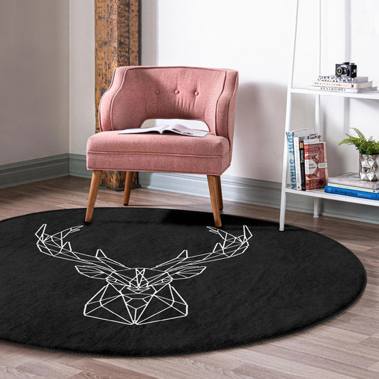 Pink upholstered accent chair on a round black rug with white geometric deer head design in a modern room