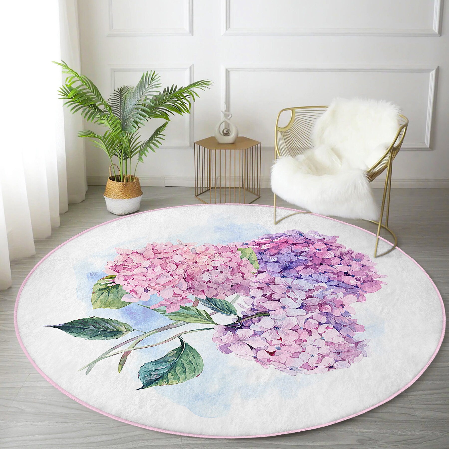 Round floral rug with pink and purple hydrangea design in modern living room with plant and gold chair